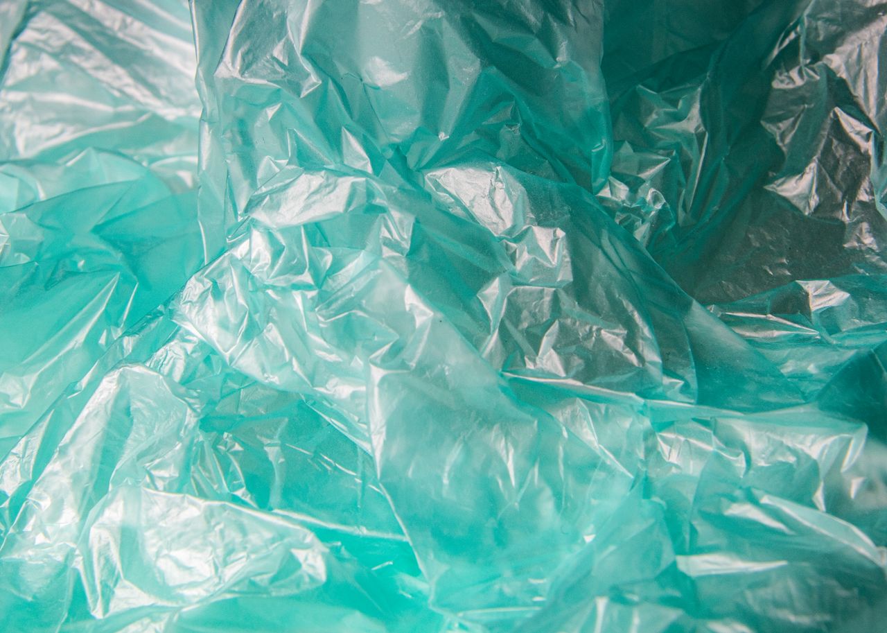 Detailed close-up of crumpled blue plastic texture showcasing patterns and transparency.